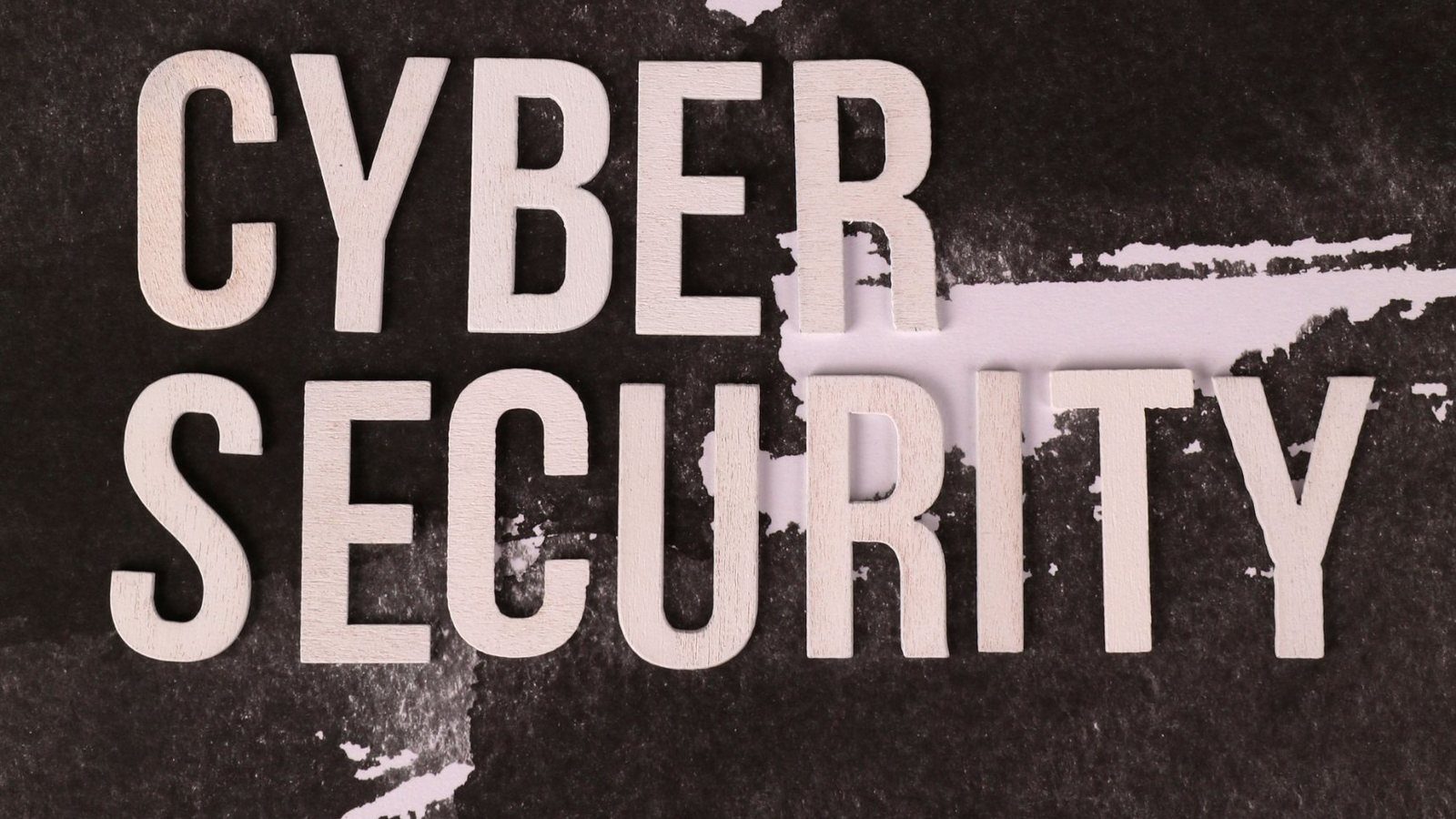 Wooden letters spelling "Cyber Security" on dark textured paper